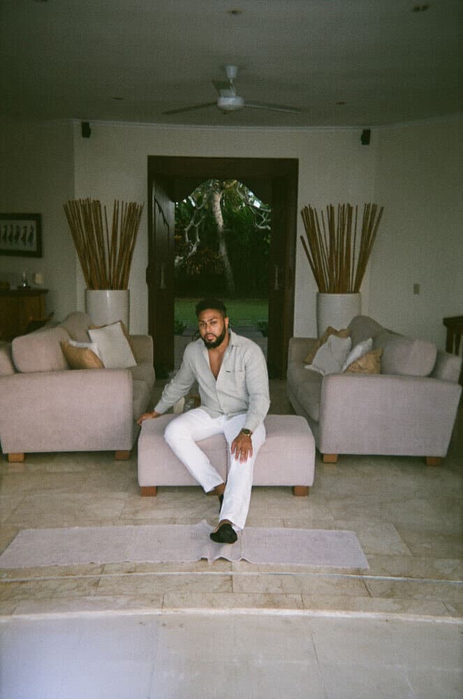 Corey seated in a sunlit living room