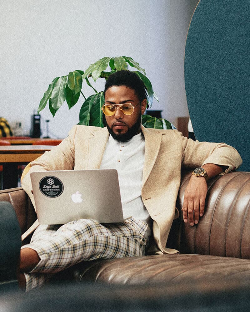Corey working on a laptop on a leather sofa