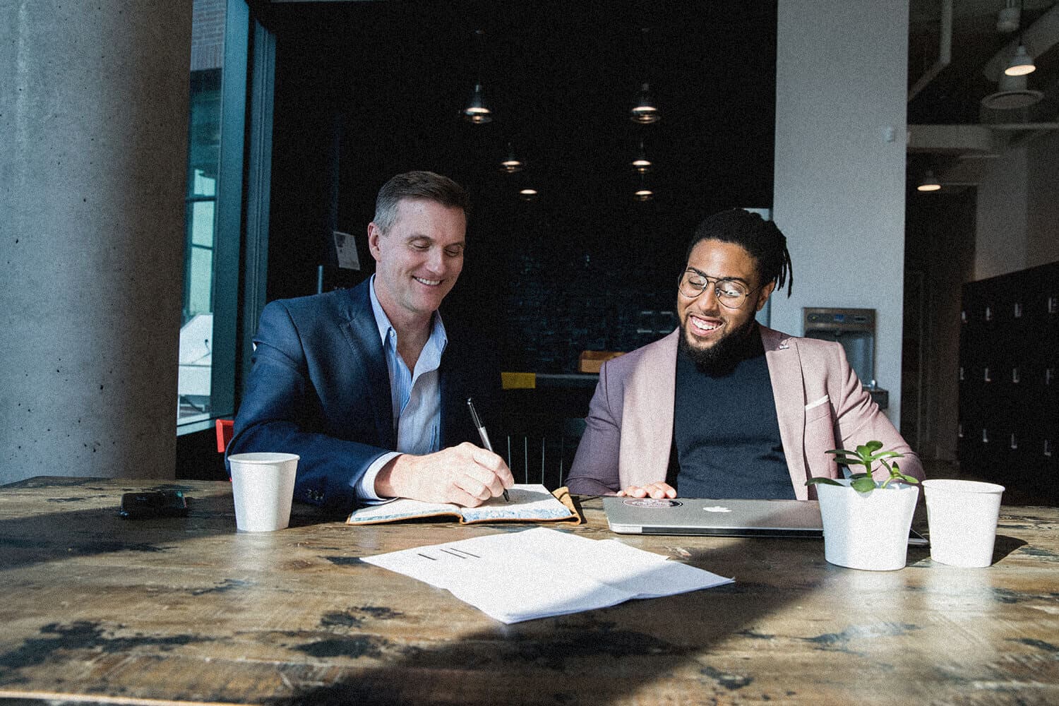 Corey and a client working through a brand strategy at a table, laughing